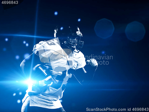 Image of American football player holding ball while running on field