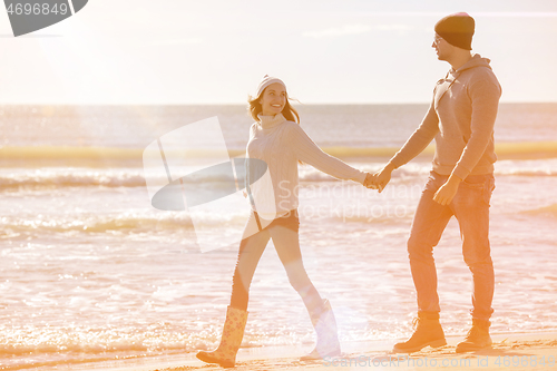 Image of Loving young couple on a beach at autumn sunny day