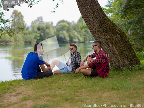 Image of men sitting on the bank of the river