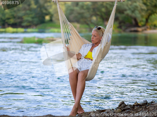 Image of blonde woman resting on hammock