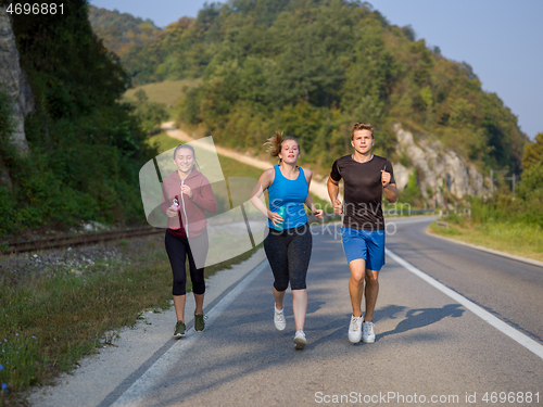 Image of young people jogging on country road