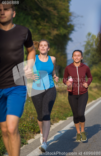 Image of young people jogging on country road