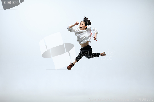 Image of Woman working at office and jumping isolated on studio background