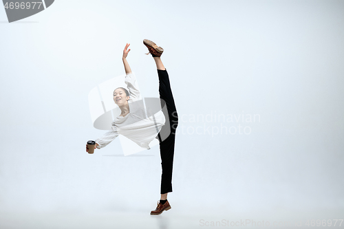 Image of Woman working at office and jumping isolated on studio background