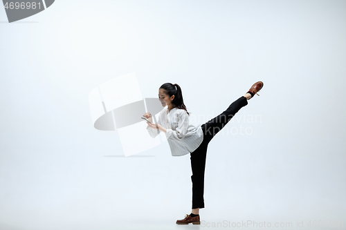 Image of Woman working at office and jumping isolated on studio background