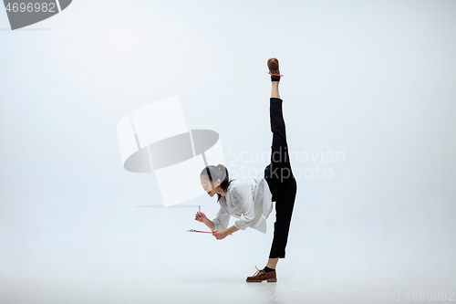 Image of Woman working at office and jumping isolated on studio background