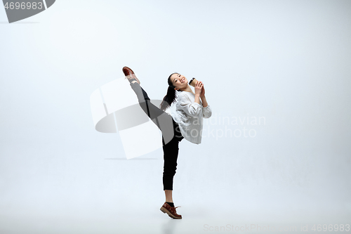 Image of Woman working at office and jumping isolated on studio background