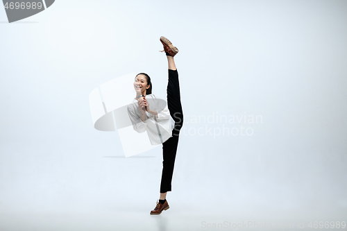 Image of Woman working at office and jumping isolated on studio background