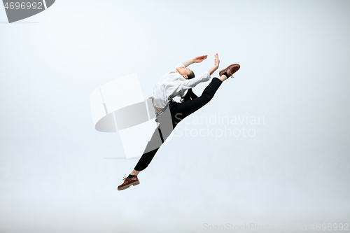 Image of Woman working at office and jumping isolated on studio background