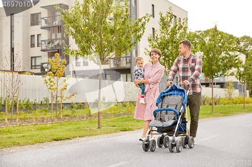 Image of family with baby and stroller walking along city