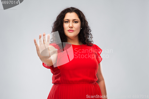 Image of woman in red dress showing stop gesture