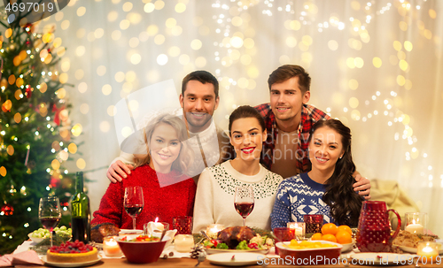 Image of happy friends celebrating christmas at home