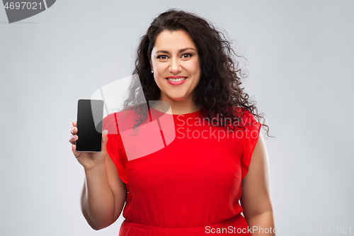 Image of happy woman in red dress showing smartphone