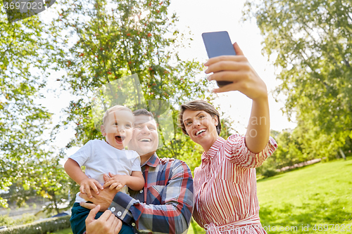 Image of happy family taking selfie at summer park