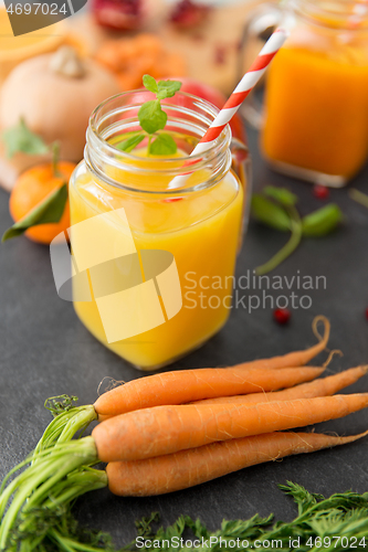 Image of mason jar glass of orange juice with paper straw