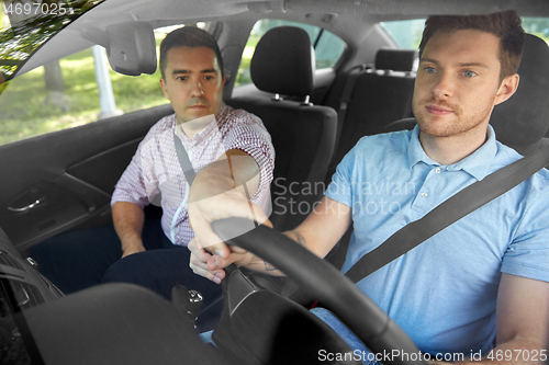 Image of car driving school instructor teaching male driver