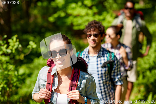 Image of group of friends with backpacks hiking in forest