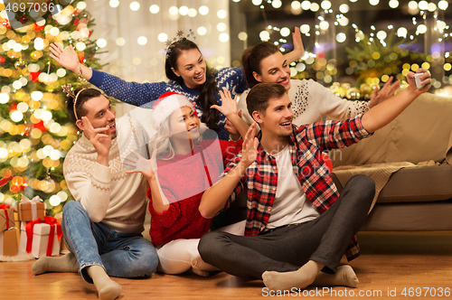 Image of friends celebrating christmas and taking selfie