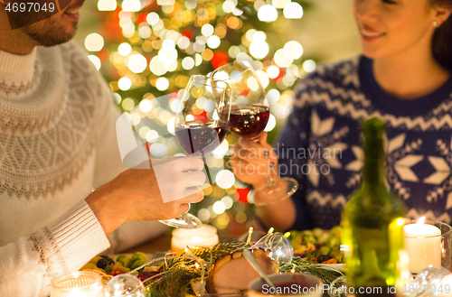 Image of happy couple drinking red wine at christmas dinner