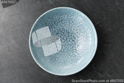 Image of close up of blue ceramic plate on slate background