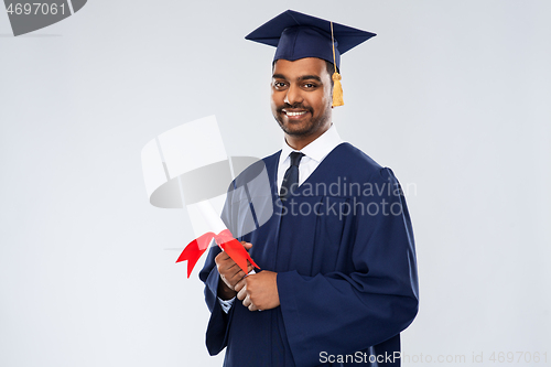 Image of male graduate student in mortar board with diploma