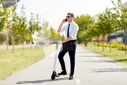 Image of businessman with scooter calling on smartphone