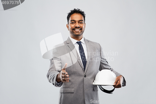 Image of male architect in helmet giving hand for handshake