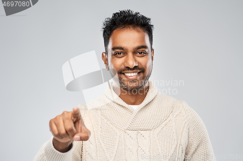 Image of smiling indian man pointing finger to camera