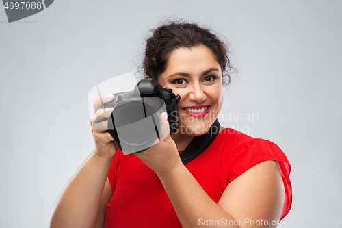 Image of happy woman photographer with digital camera