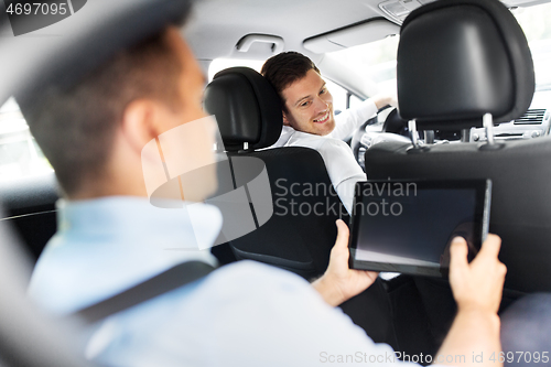 Image of male car driver and passenger with tablet pc