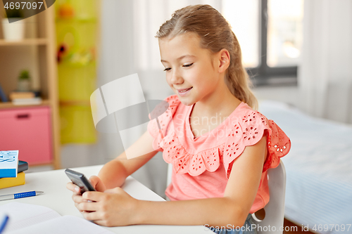 Image of happy student girl using smartphone at home