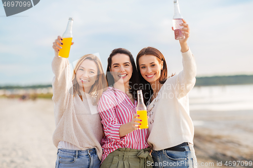 Image of young women toasting non alcoholic drinks on beach