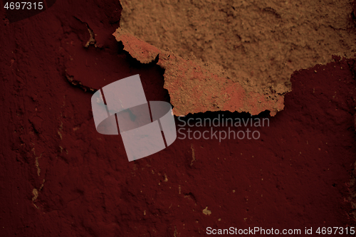 Image of Detail of flaking plaster on a dark red wall