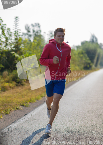 Image of man jogging along a country road