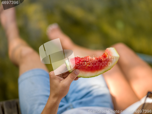 Image of Couple eating watermelon enjoying picnic time
