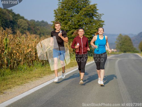 Image of young people jogging on country road