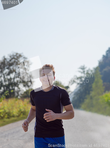 Image of man jogging along a country road