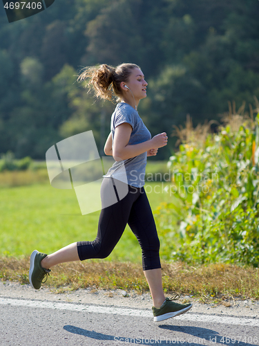 Image of woman jogging along a country road