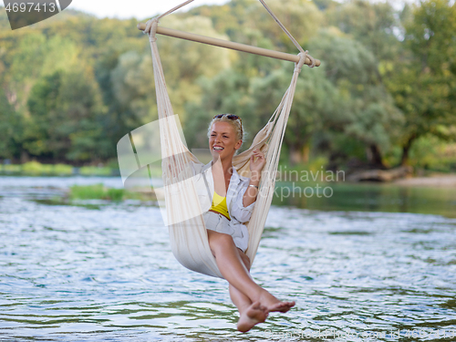 Image of blonde woman resting on hammock