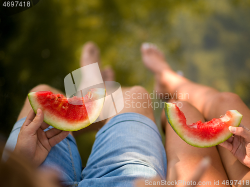 Image of Couple eating watermelon enjoying picnic time