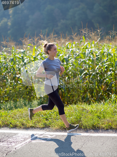 Image of woman jogging along a country road