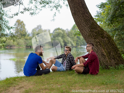 Image of men sitting on the bank of the river