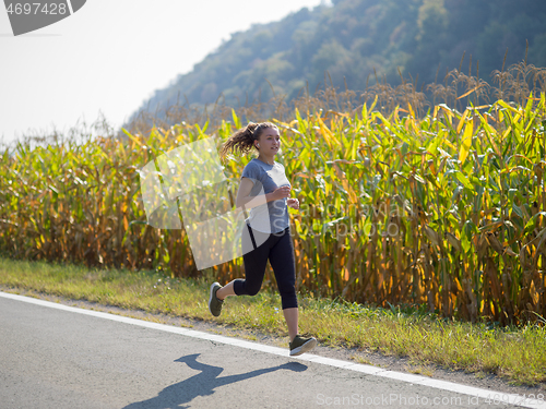 Image of woman jogging along a country road