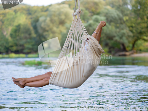 Image of blonde woman resting on hammock