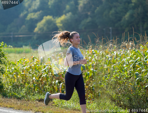 Image of woman jogging along a country road