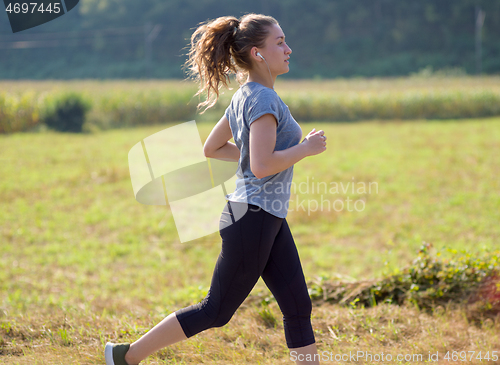 Image of woman jogging along a country road