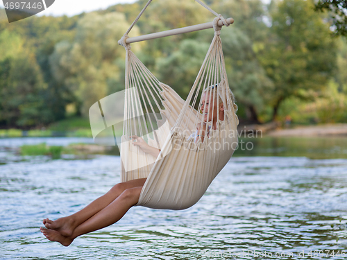 Image of blonde woman resting on hammock