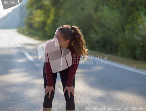 Image of woman jogging along a country road