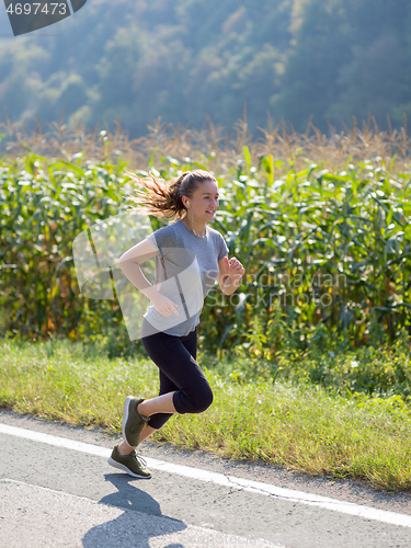 Image of woman jogging along a country road