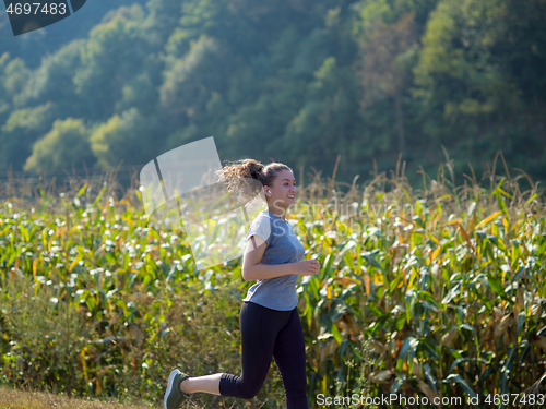Image of woman jogging along a country road